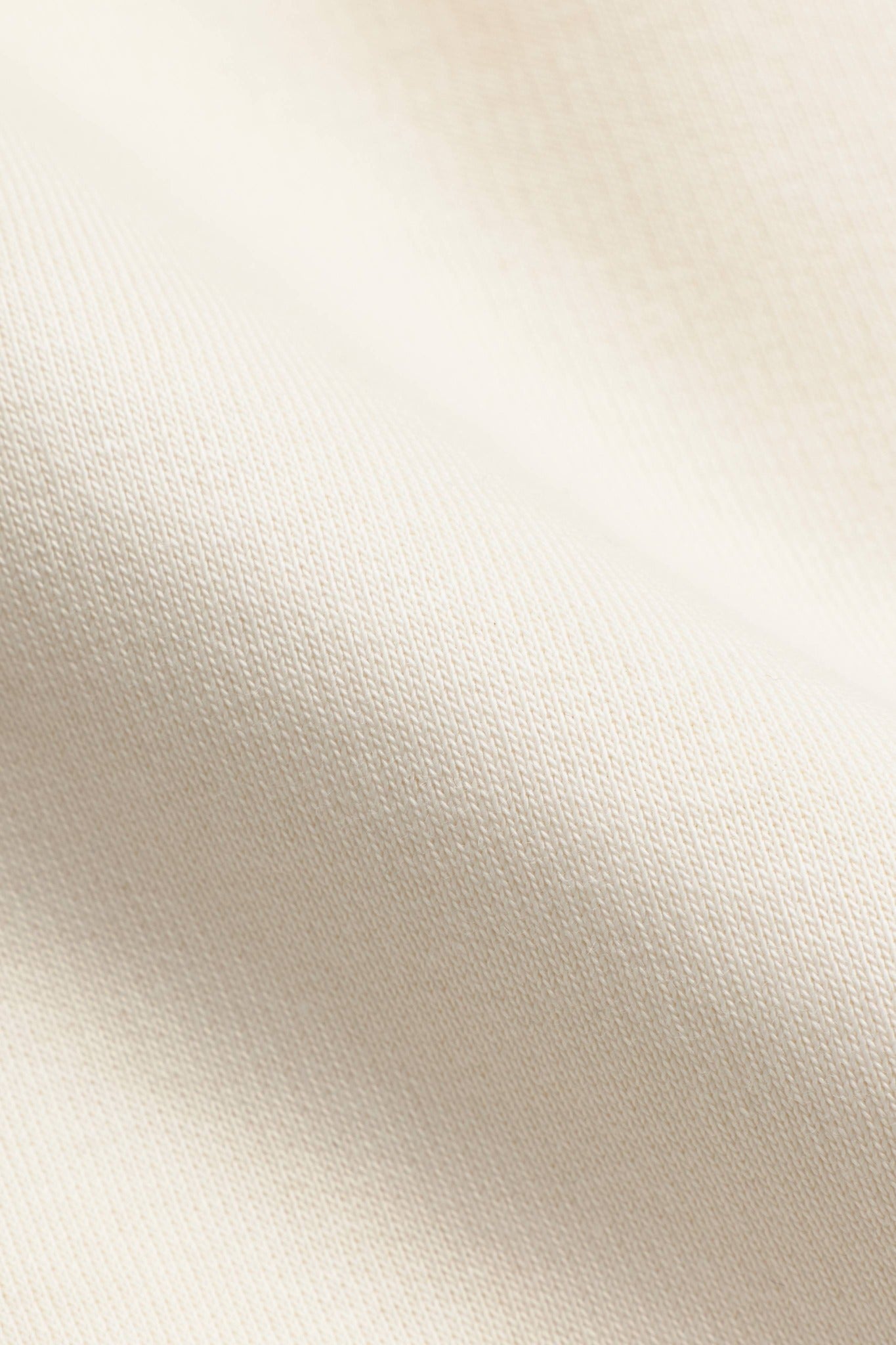 Close-up of the creme heavyweight fabric texture on a CASPARA Cosmo zip hoodie.